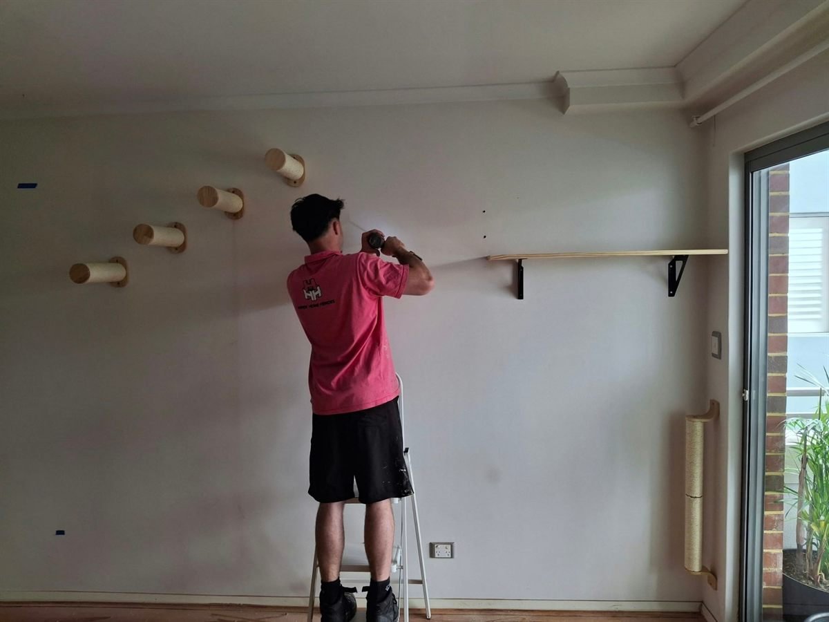 Fixing a shelf bracket for the cat climbing wall, with the sisal steps already in place