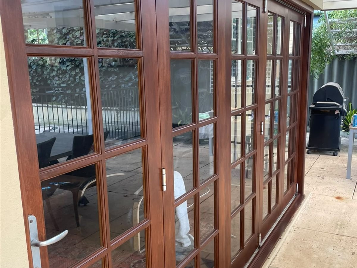 The same timber French doors after restoration, re-stained to a deep red-brown finish